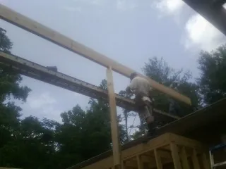 Carpenter setting a ridge beam over a new addition frame — Ice Dam Removal by Roofing Brothers in Lees Summit