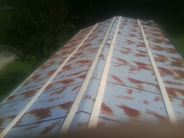 Rusted metal roof panels with new wood purlins before replacement — Storm Damage Roof Repair in Lees Summit by Roofing Brothers
