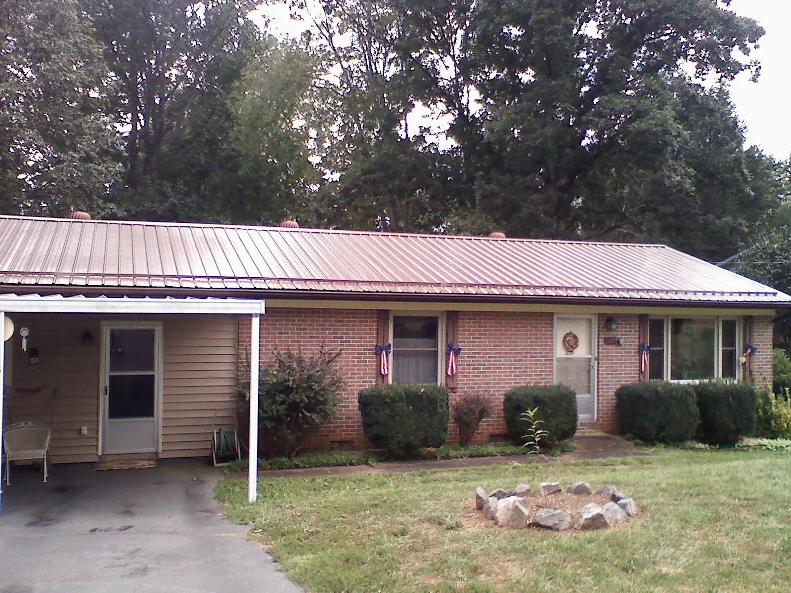 Bronze metal roof and carport on a brick ranch home — Roof Repair work by our crew in Lees Summit